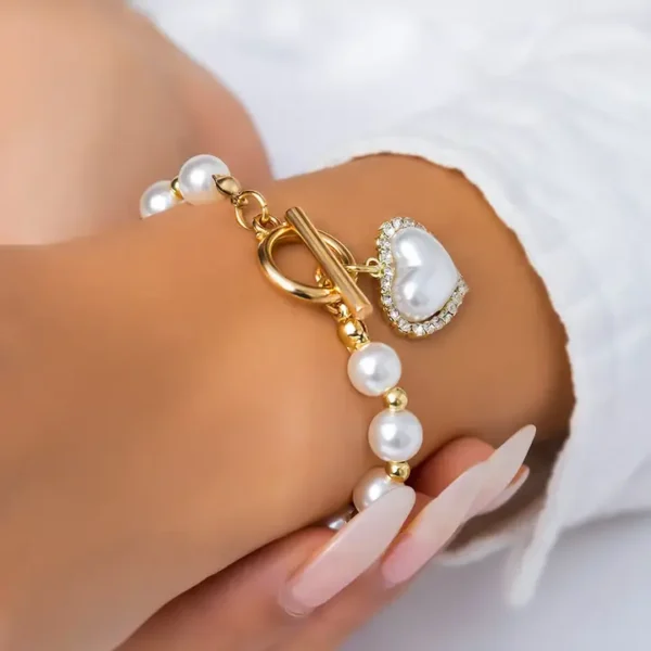 Bracelet de perle et strass plaqué or en forme de cœur.