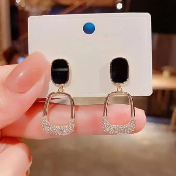 Boucle d'oreilles pendantes avec nœud en forme de boule de cheveux.